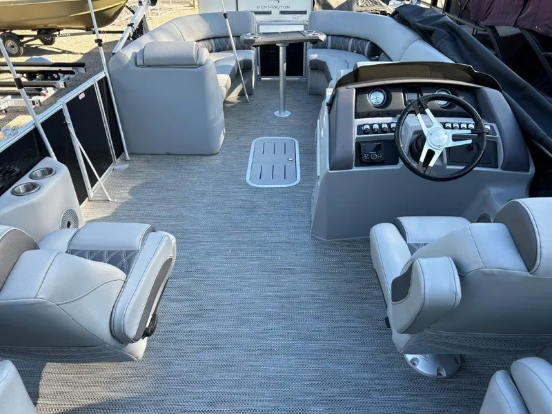 Slide: The Image of 2022 Bennington 26LXFB pontoon boat interior with gray seating and modern helm. - 3