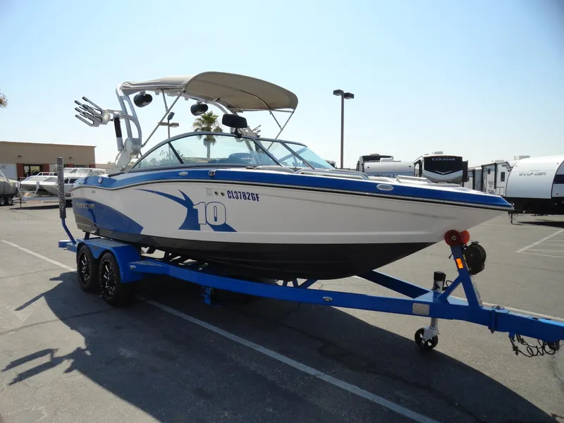 Slide: The Image of 2013 MasterCraft X-10 boat on a blue trailer in a parking lot. - 4