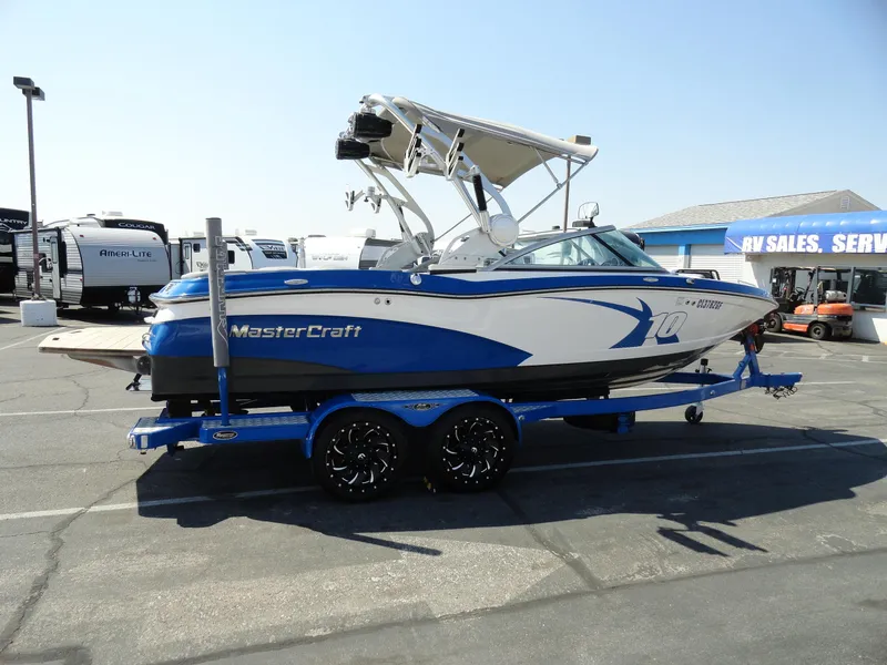 Slide: The Image of 2013 MasterCraft X-10 boat in blue and white on a trailer at a dealership. - 5