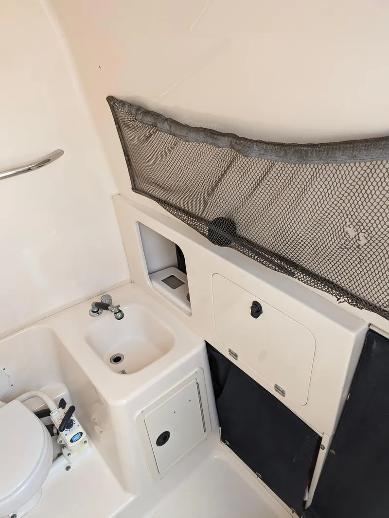 Slide: The Image of 2000 Grady-White Bimini 306 boat interior with sink and storage compartments. - 11