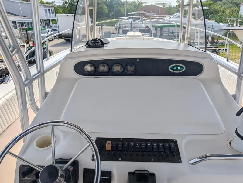 Slide: The Image of Grady-White Bimini 306 2000 boat dashboard with steering wheel and control panel. - 12