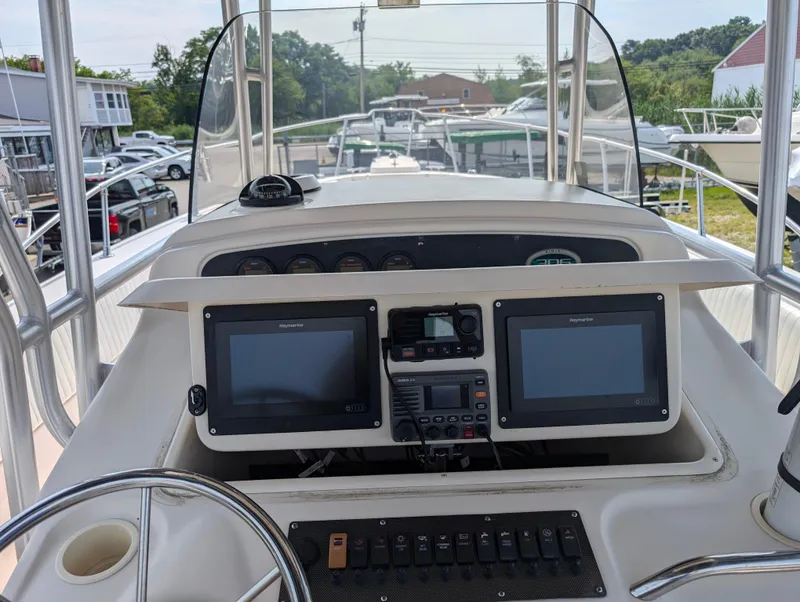Slide: The Image of 2000 Grady-White Bimini 306 boat dashboard with dual navigation screens and control panel. - 23