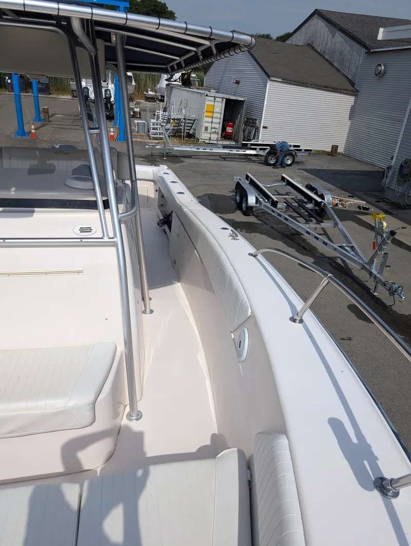 Slide: The Image of 2000 Grady-White Bimini 306 boat interior with white seating and docked trailer. - 6