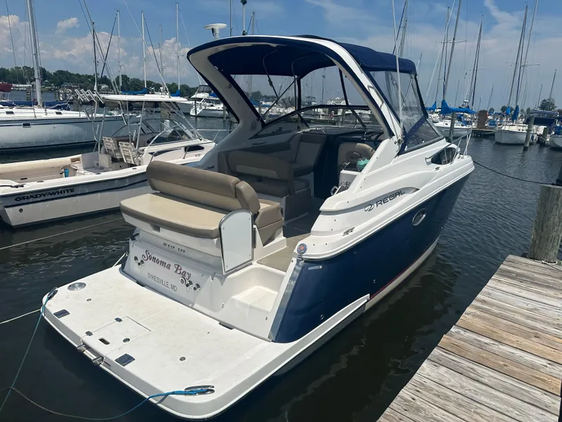 Slide: The Image of 2014 Regal 30 Express boat docked at a marina with other boats. - 2