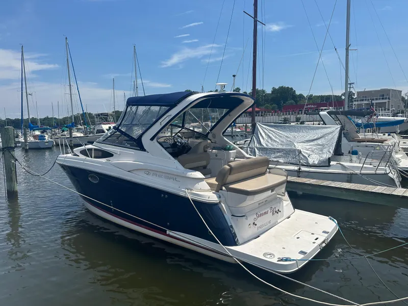 Slide: The Image of 2014 Regal 30 Express boat docked at a marina with other sailboats. - 22
