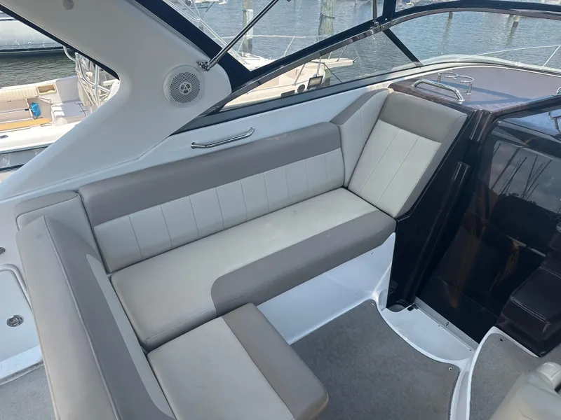 Slide: The Image of 2014 Regal 30 Express boat interior seating area with beige and white upholstery. - 9