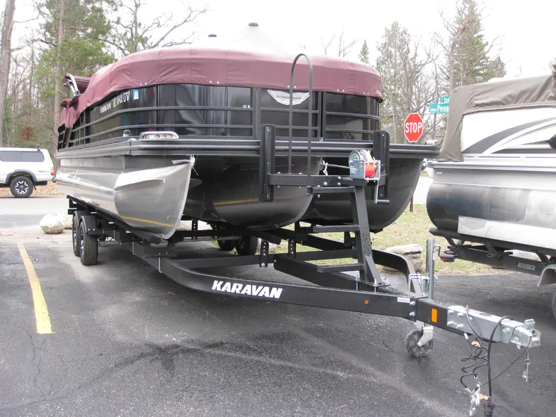 Slide: The Image of 2021 Bennington 23RFBSD pontoon boat on Karavan trailer, parked outdoors. - 1