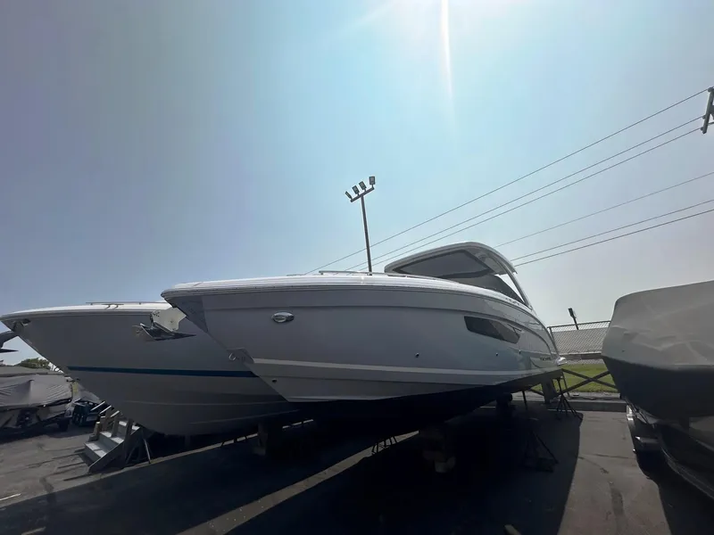 Slide: The Image of 2025 Regal 3300 boat on display in a marina under bright sunlight. - 1