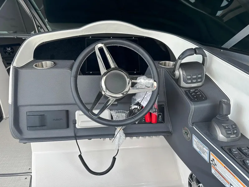 Slide: The Image of 2025 Regal 3300 boat helm with steering wheel and control panel. - 12