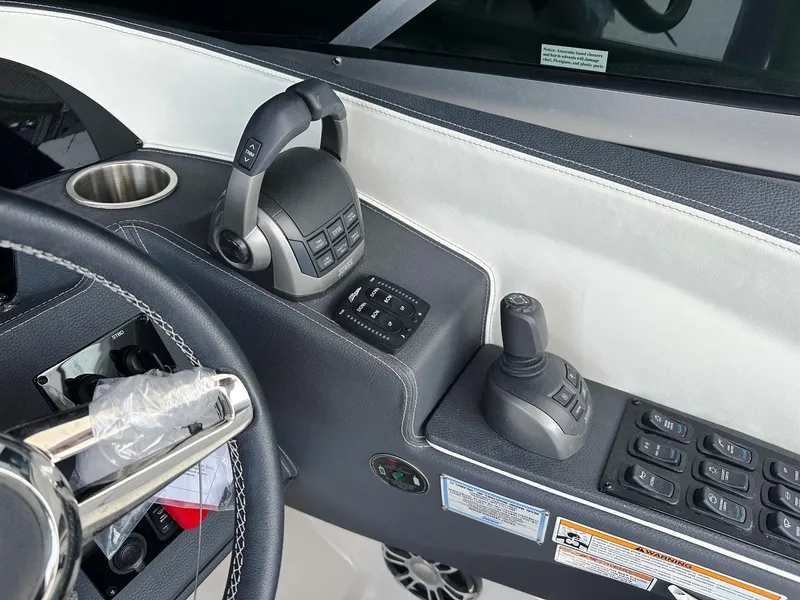 Slide: The Image of Control panel of a 2025 Regal 3300 boat with steering wheel and throttle. - 13