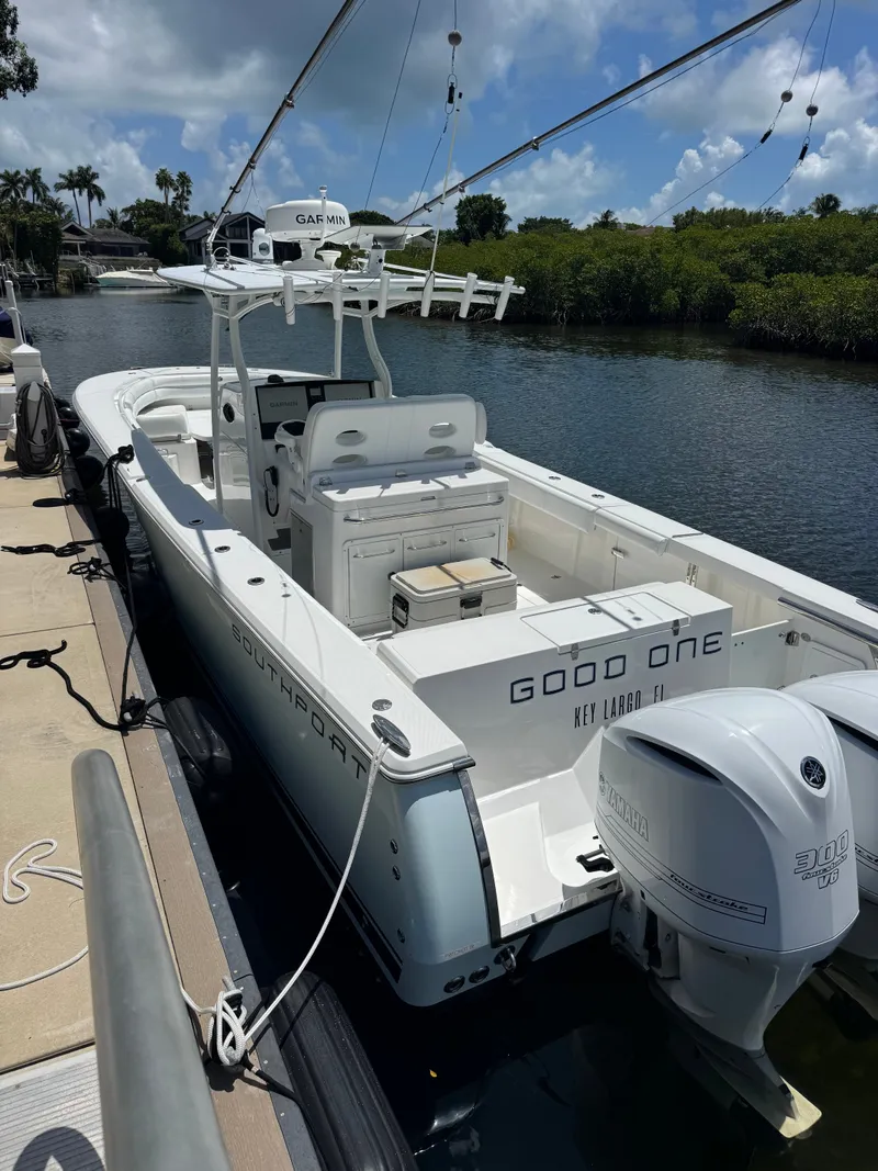 Slide: The Image of A 2015 Southport 33 boat docked. It features twin outboard engines and a spacious deck. - 15