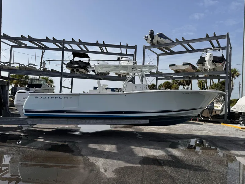 Slide: The Image of A 2015 Southport 33 boat is on a dry dock. It features a white hull design. - 3