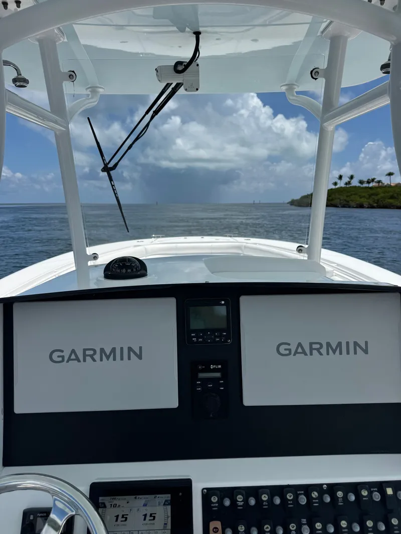Slide: The Image of The cockpit of a 2015 Southport 33 with two Garmin screens and a clear view of the water. - 29