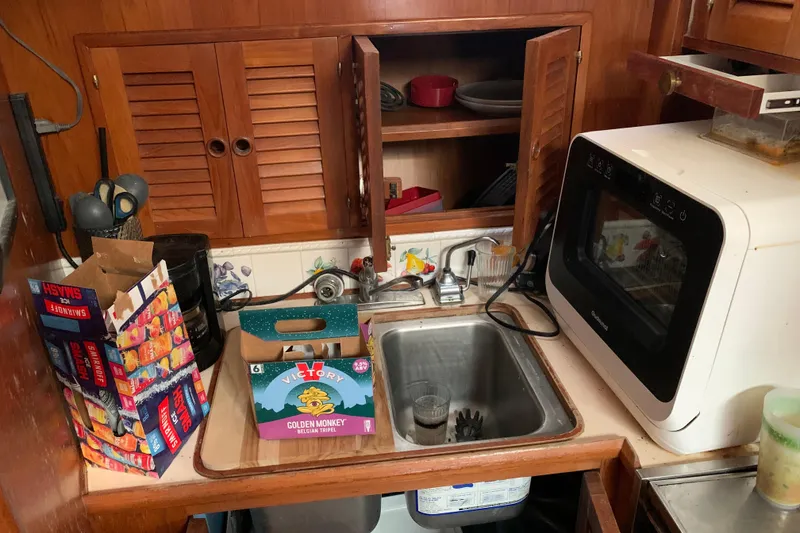 Slide: The Image of Compact kitchen area in a 1984 Jefferson 45 Motor Yacht with sink and microwave. - 12
