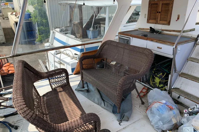 Slide: The Image of 1984 Jefferson 45 Motor Yacht deck with wicker seating and storage area. - 3
