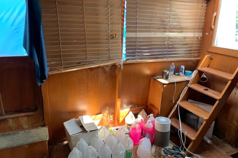 Slide: The Image of Interior of 1984 Jefferson 45 Motor Yacht with wooden paneling and various cleaning supplies. - 8