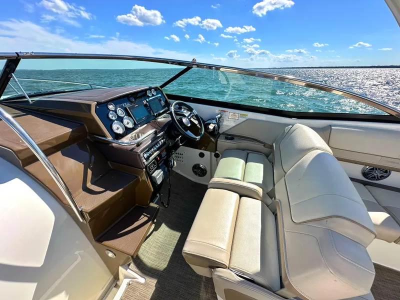 Slide: The Image of 2015 Formula 310 Sun Sport boat interior with steering wheel and seating, on a sunny day. - 21