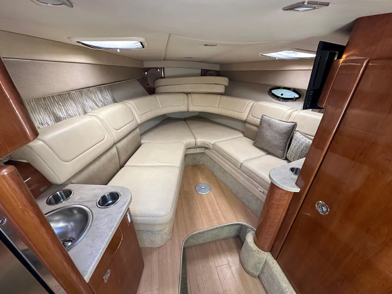 Slide: The Image of 2015 Formula 310 Sun Sport cabin interior with beige seating and wood accents. - 26