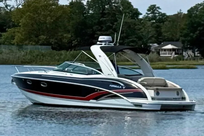 Slide: The Image of 2015 Formula 310 Sun Sport boat on a calm lake with trees in the background. - 3