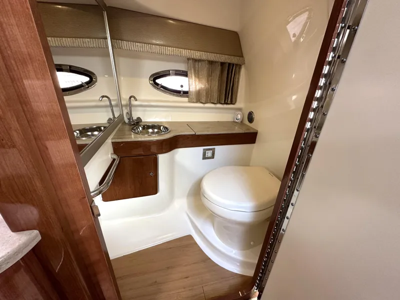 Slide: The Image of 2015 Formula 310 Sun Sport boat bathroom with sink, toilet, and wooden cabinetry. - 30