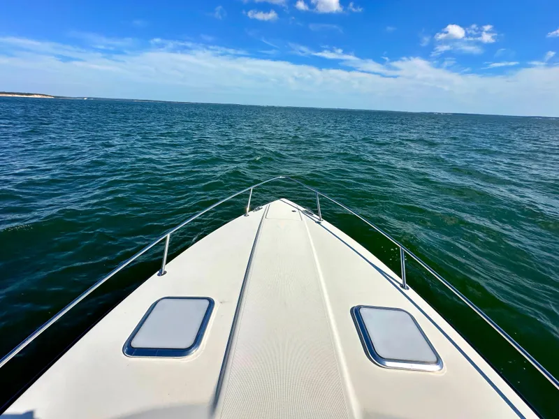 Slide: The Image of 2015 Formula 310 Sun Sport boat cruising on open water under a clear blue sky. - 36