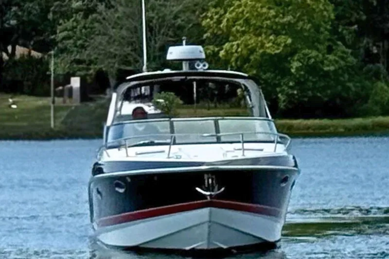 Slide: The Image of 2015 Formula 310 Sun Sport boat on a serene lake with lush greenery. - 6