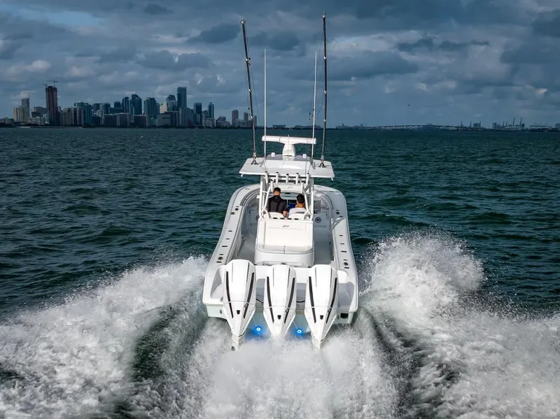 Slide: The Image of 2023 Yellowfin 36 boat cruising on water with city skyline in background. - 18