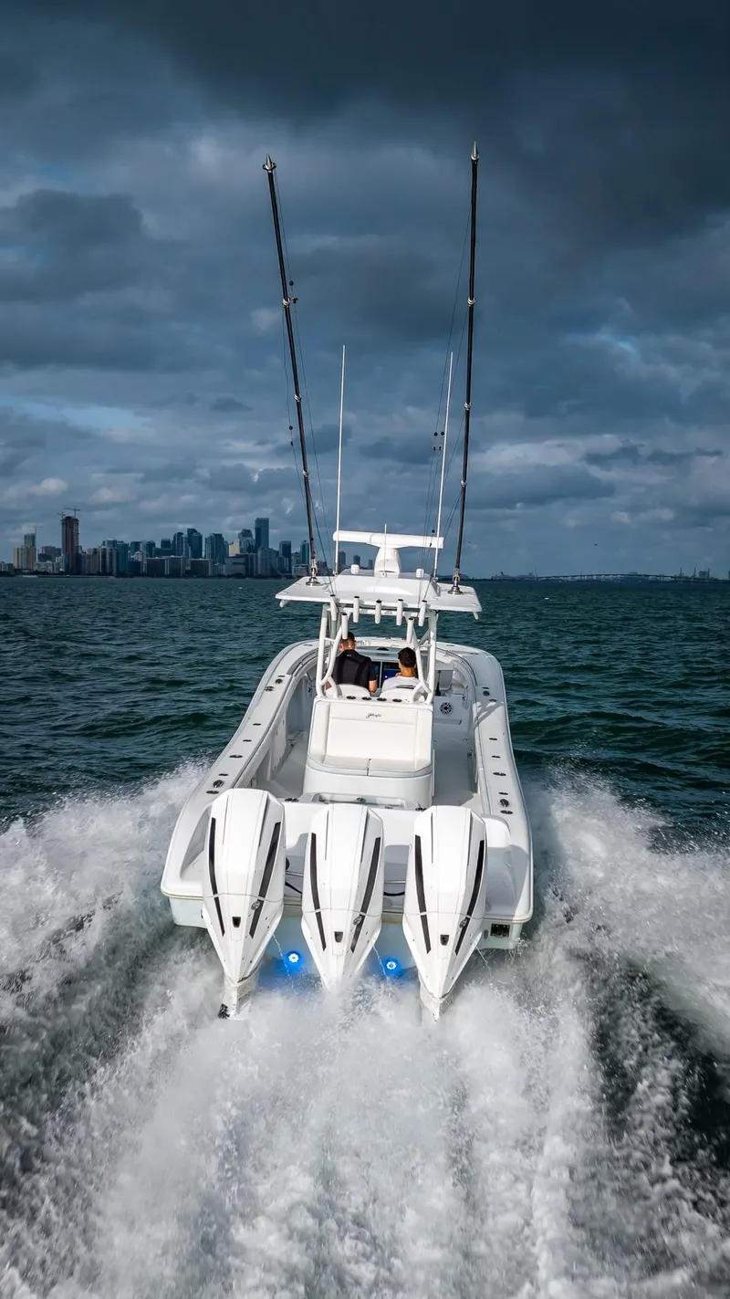 Slide: The Image of 2023 Yellowfin 36 boat cruising on open water with city skyline. - 19