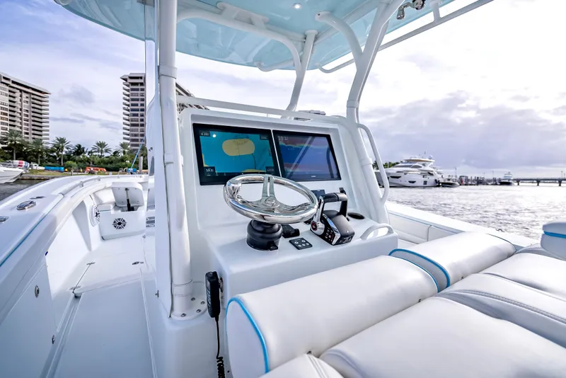 Slide: The Image of 2023 Yellowfin 36 boat dashboard with modern navigation system, docked at marina. - 25