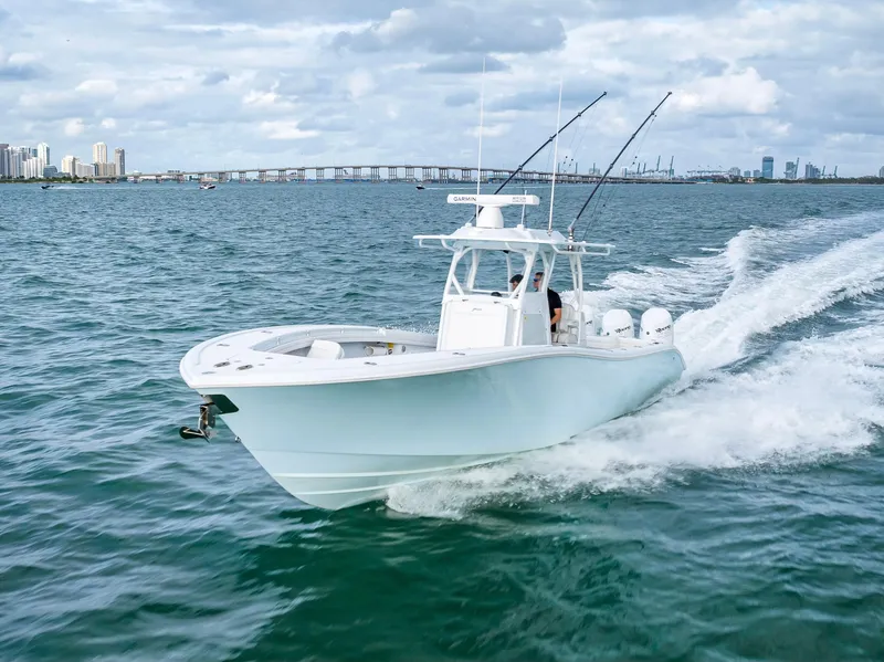 Slide: The Image of 2023 Yellowfin 36 boat cruising on open water with city skyline in background. - 5