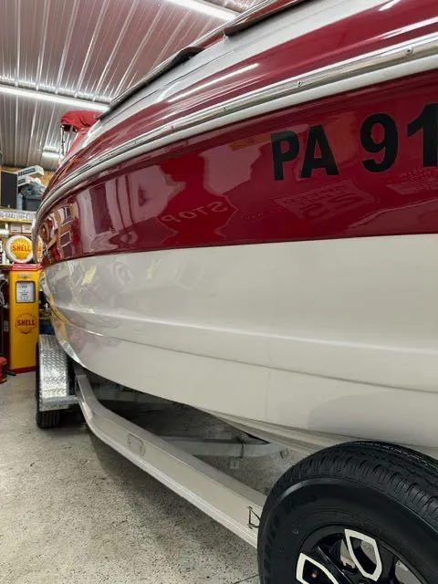 Slide: The Image of 2011 Crownline BOWRIDER 245 SS boat in a garage, side view. - 16