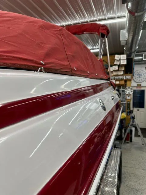 Slide: The Image of 2011 Crownline BOWRIDER 245 SS with red cover in a garage. - 7