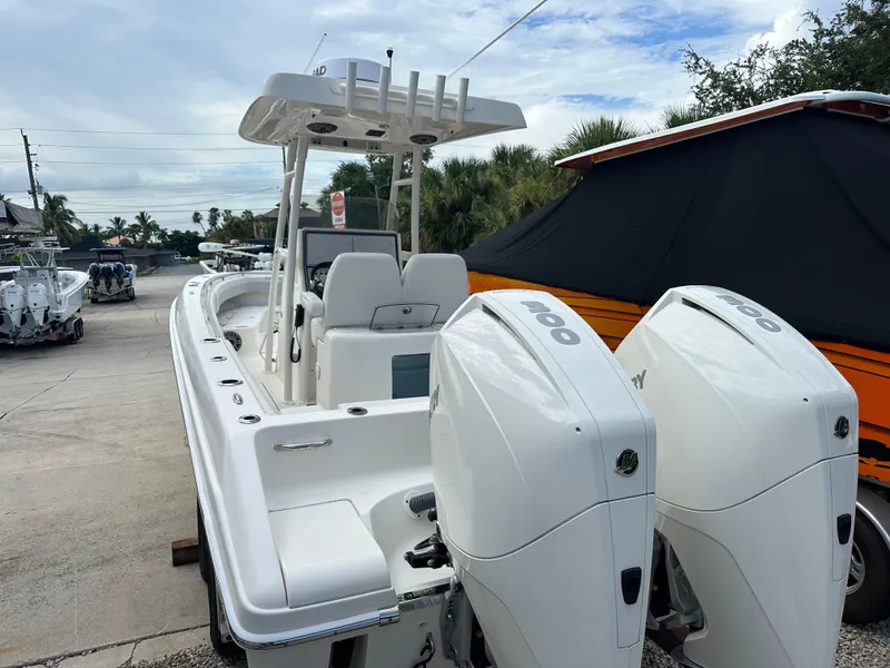 Slide: The Image of 2023 Blackwood 27HD boat with dual outboard engines, docked outdoors. - 13