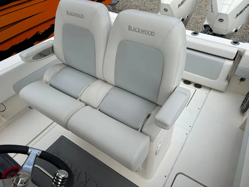 Slide: The Image of Luxury seating on 2023 Blackwood 27HD boat with dual outboard motors. - 24