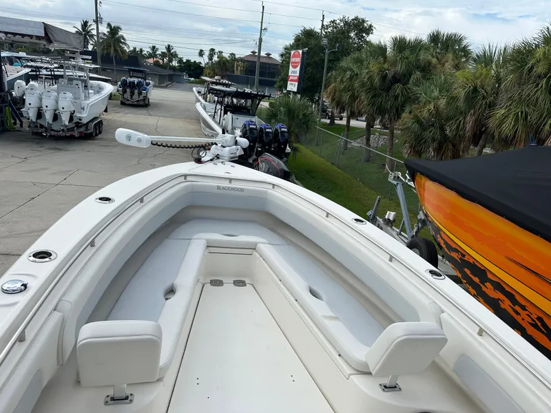 Slide: The Image of 2023 Blackwood 27HD boat with spacious seating, docked near other boats and palm trees. - 25