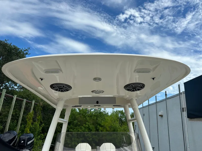 Slide: The Image of 2023 Blackwood 27HD boat with T-top and speakers under a blue sky. - 27