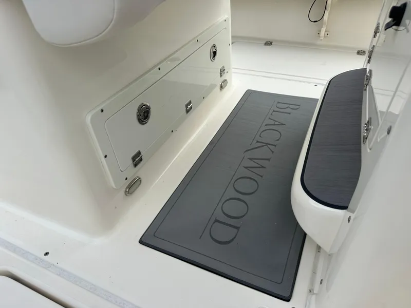 Slide: The Image of 2023 Blackwood 27HD boat interior with branded floor mat and storage compartment. - 34
