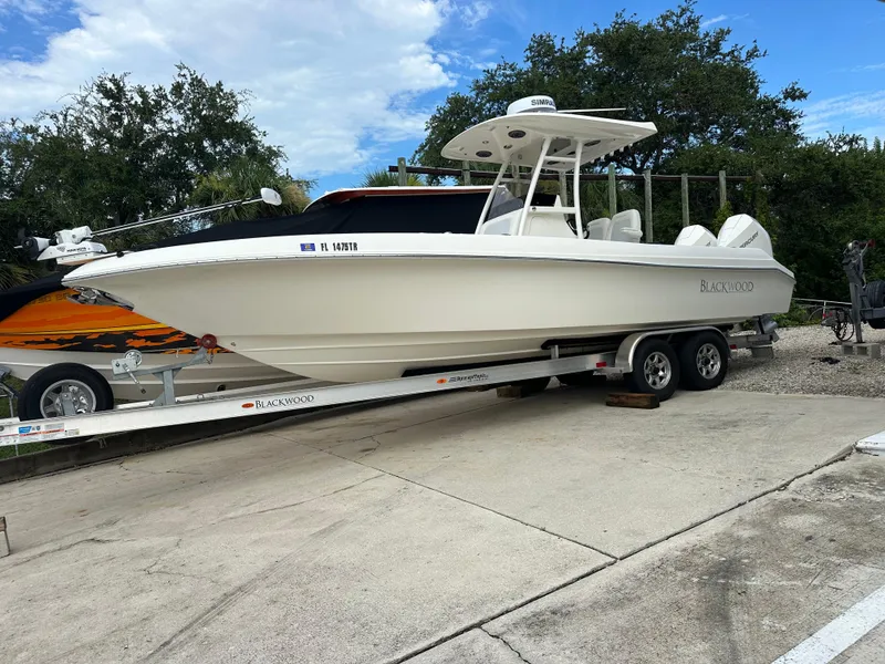Slide: The Image of 2023 Blackwood 27HD boat on trailer, parked outdoors under a cloudy sky. - 7