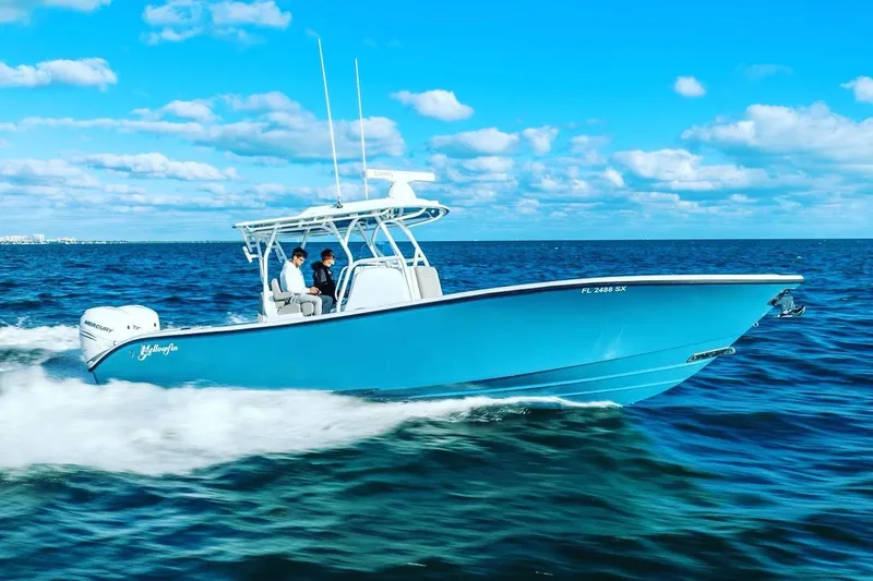 Slide: The Image of 2025 Yellowfin 32 boat cruising on open water under a clear blue sky. - 2