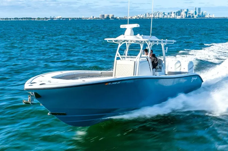 Slide: The Image of 2025 Yellowfin 32 boat cruising on open water with city skyline in background. - 4