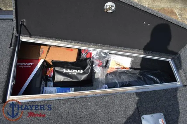 Slide: The Image of Storage compartment of 2025 Lund 1875 Pro-V Bass XS boat with various items. - 18