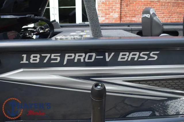 Slide: The Image of 2025 Lund 1875 Pro-V Bass XS boat side view with branding. - 4