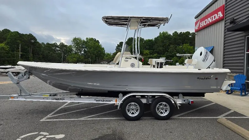 Slide: The Image of 2025 Bulls Bay 2200 boat on trailer outside Honda dealership. - 2