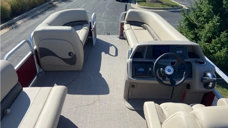 Slide: The Image of 2024 Sun Tracker Party Barge 18 DLX interior with beige seating and steering console. - 3