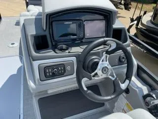 Slide: The Image of 2024 Regency 230 DL3 boat dashboard with steering wheel and navigation system. - 6