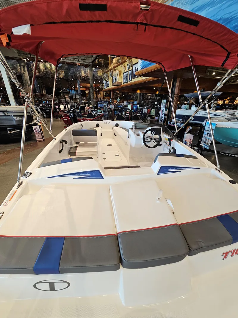 Slide: The Image of 2024 Tahoe T18 boat with red canopy in showroom. - 2
