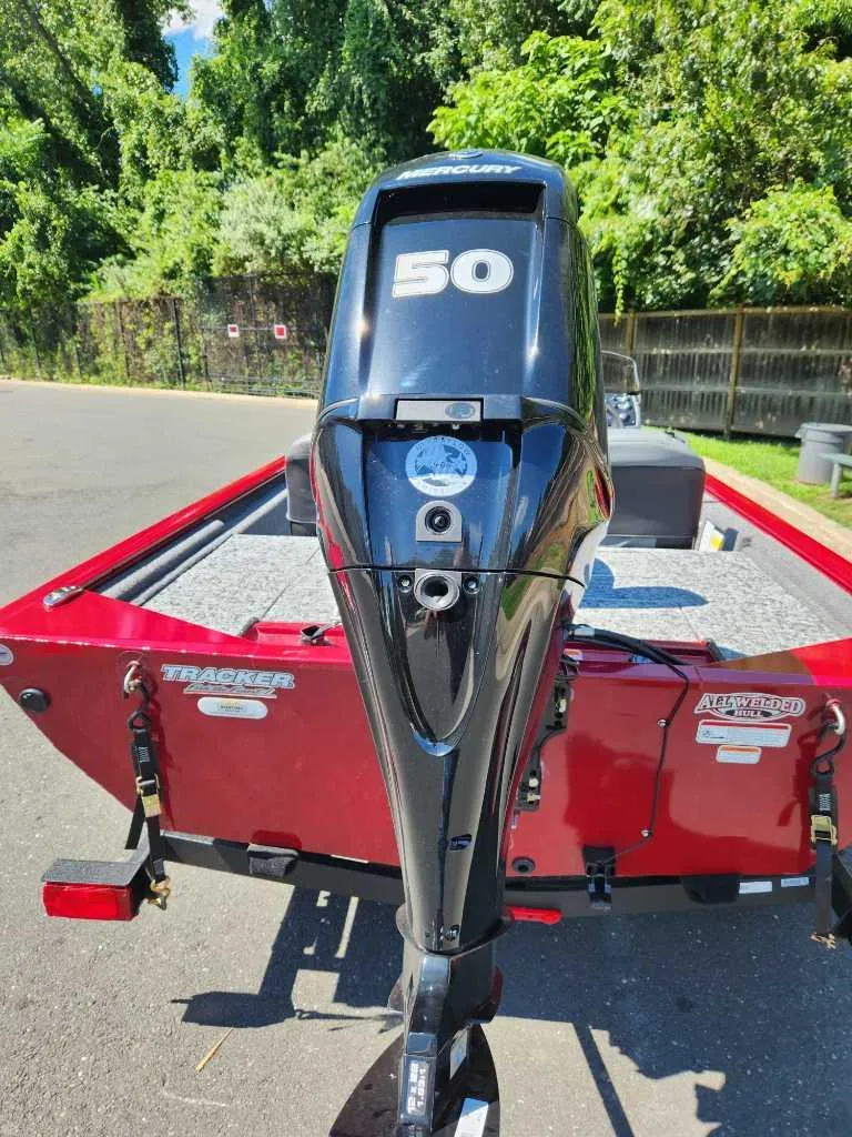 Slide: The Image of 2024 Tracker Pro 170 boat with 50 HP motor, red exterior, parked outdoors. - 3