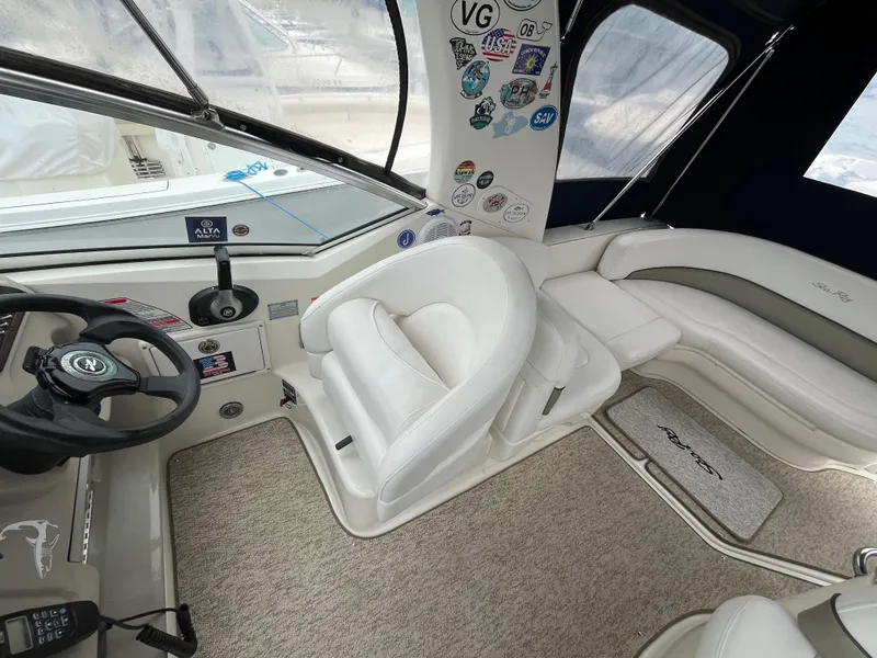 Slide: The Image of Interior of a 2006 Sea Ray 260 Sundancer boat with white seating and steering wheel. - 10