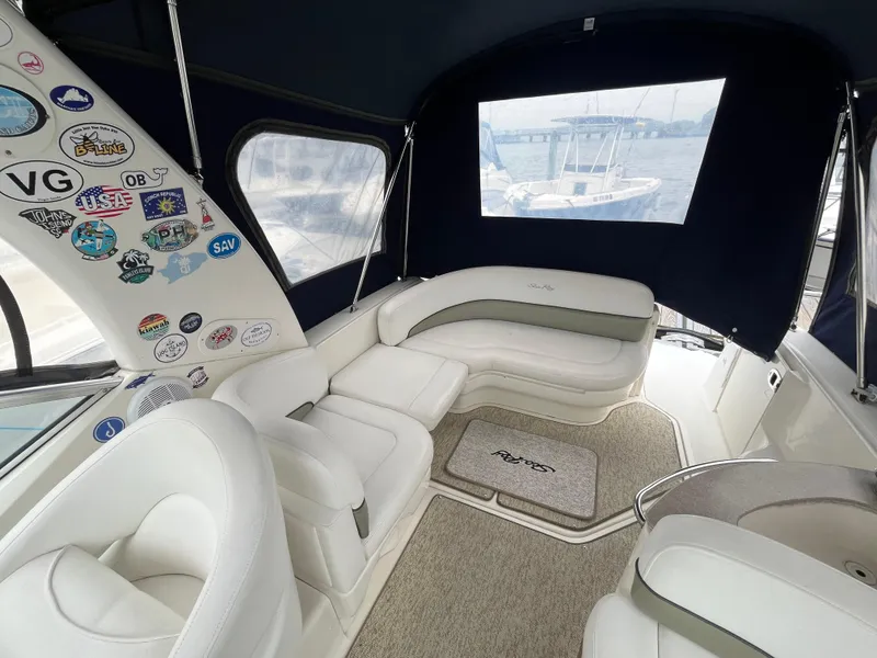 Slide: The Image of 2006 Sea Ray 260 Sundancer interior with white seating and nautical stickers. - 11