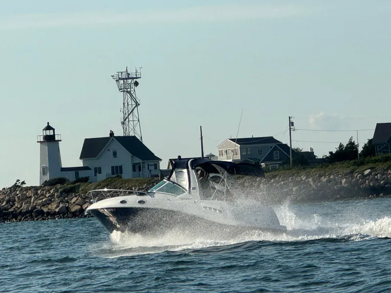 Slide: The Image of Sea Ray 260 Sundancer 2006 cruising near a coastal lighthouse and houses. - 6